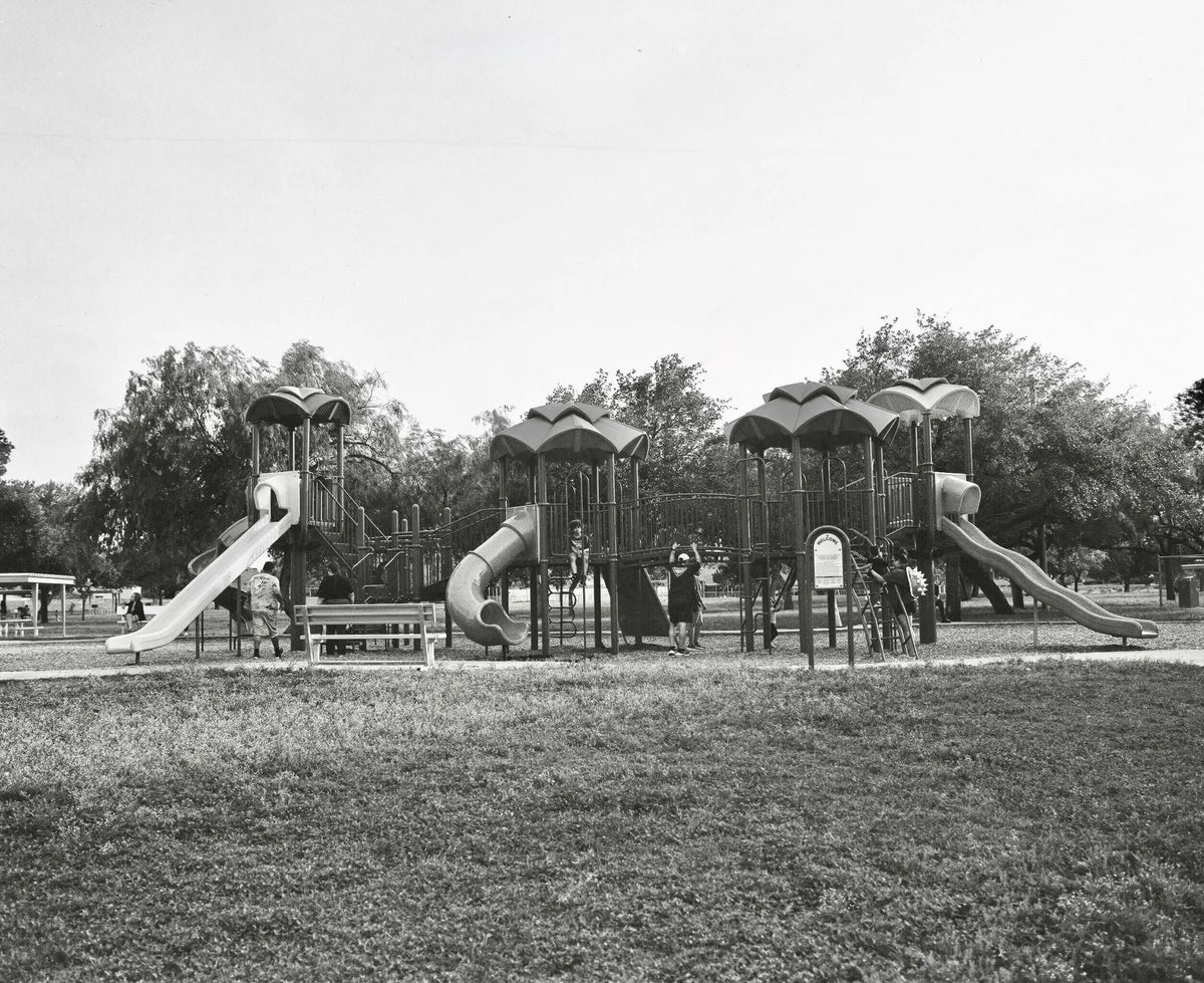 Black-and-white playground structure with multiple slides and climbing areas