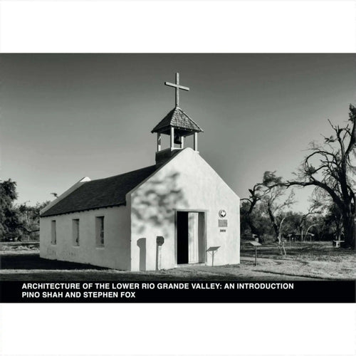 A small, white adobe church with a bell tower topped by a cross.