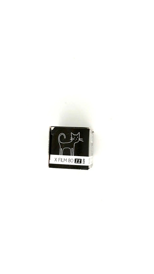 Black and white x film 80 roll film package featuring a minimalist cat illustration.