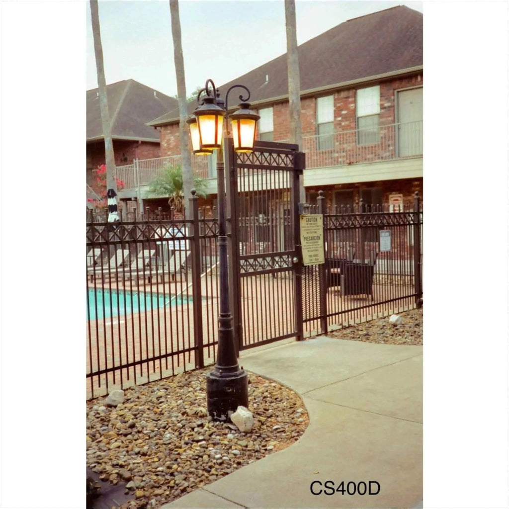 Black wrought iron lamppost with two glowing lanterns.