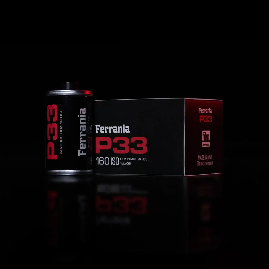 Ferrania p33 panoramic film canister in sleek black with bold red lettering, housed beside its matching box.