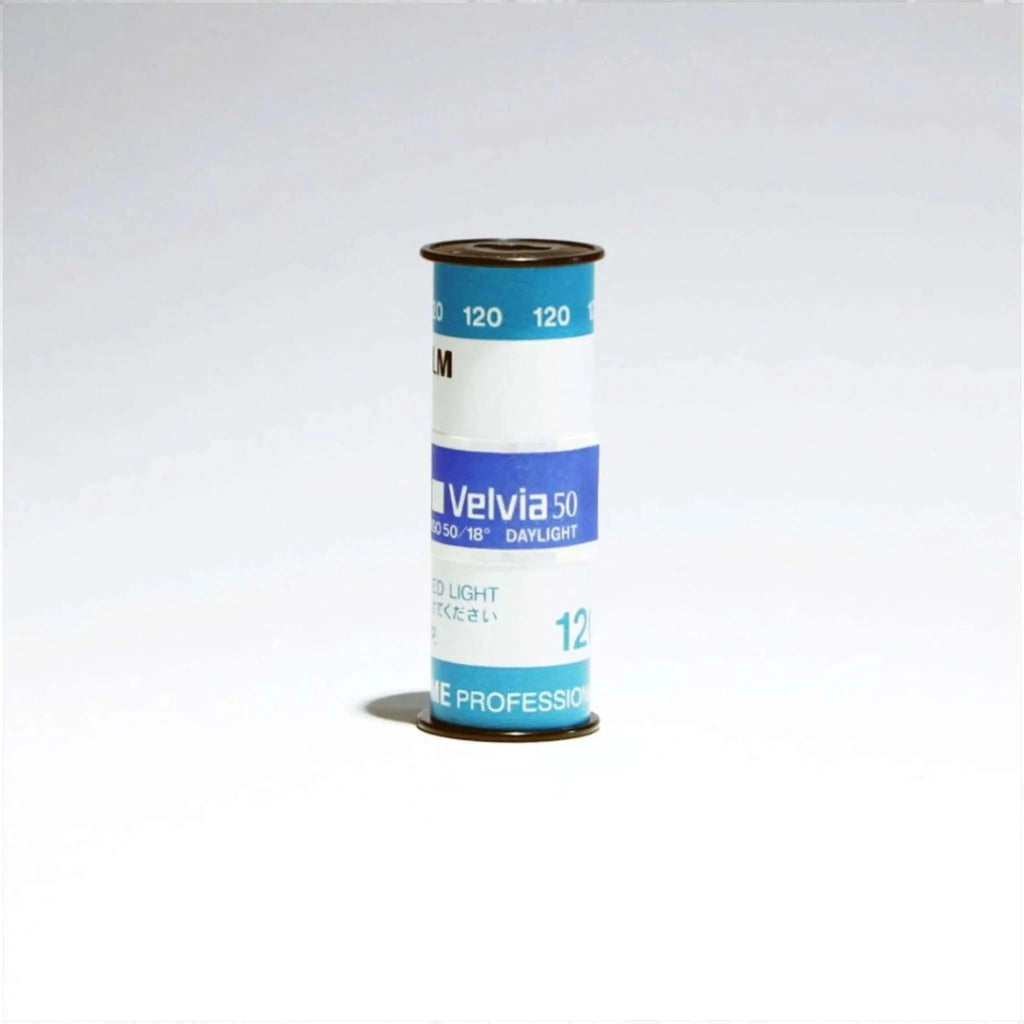 A cylindrical roll of kodak velvia 50 film, featuring a blue and white label with black text.