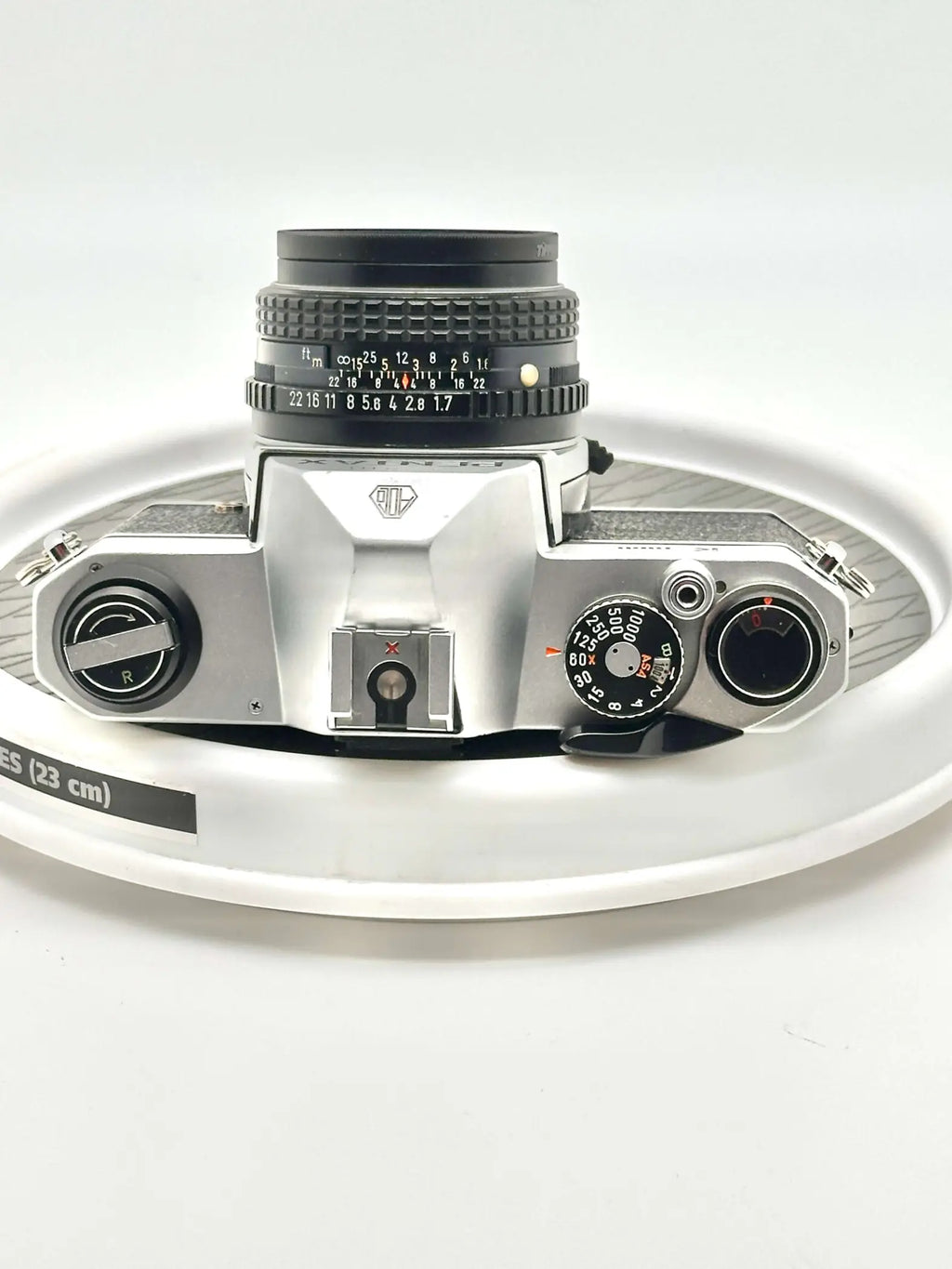 Silver-bodied canon ae-1 film camera with a black lens and textured grip.