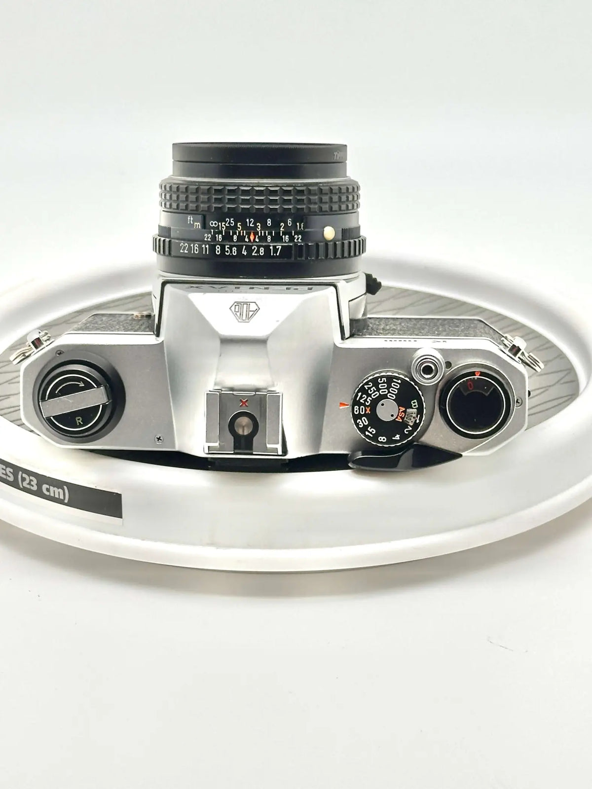 Silver-bodied canon ae-1 film camera with a black lens and textured grip.