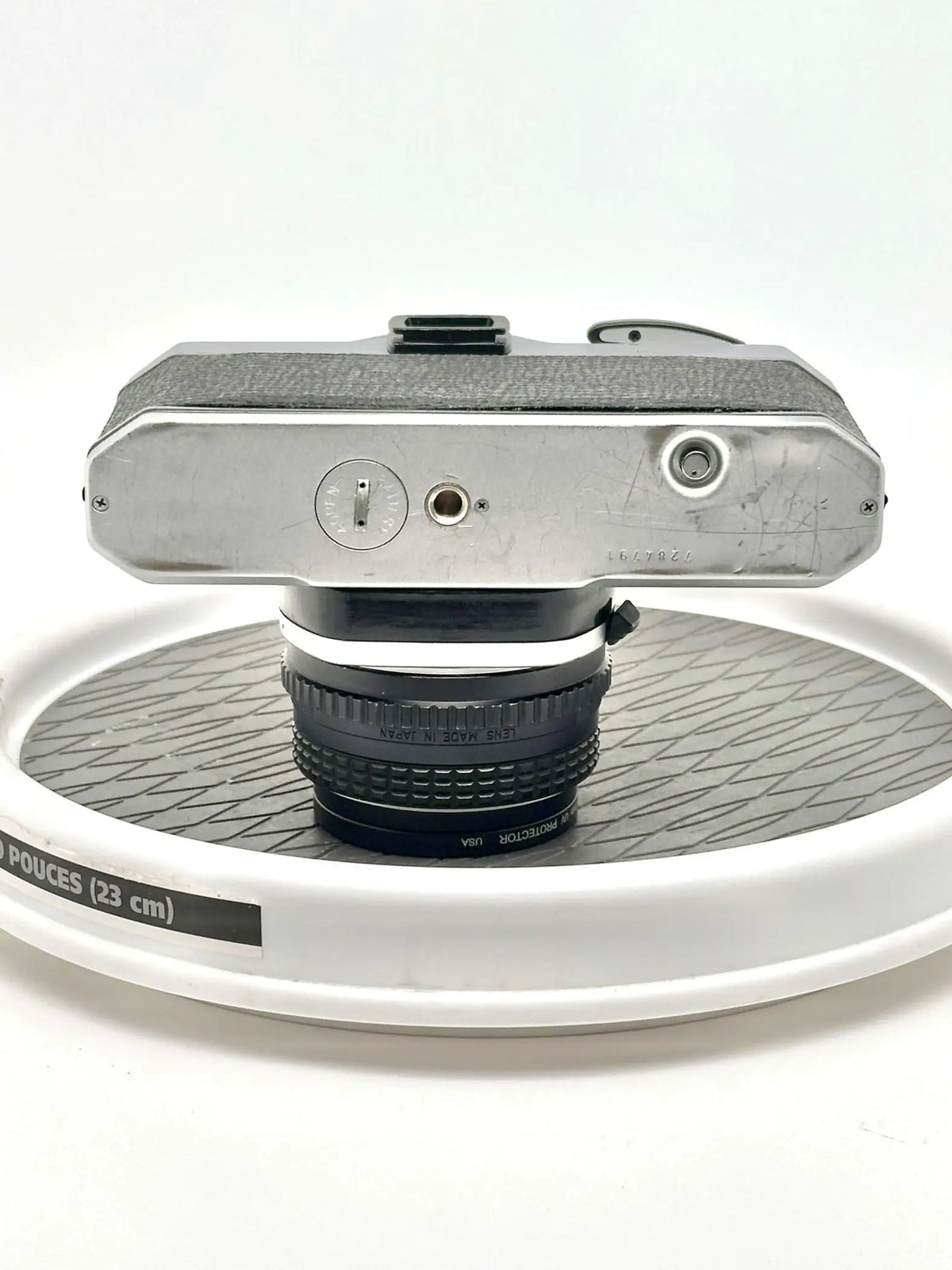 Silver-bodied vintage camera with textured grip and a black lens mounted on top.
