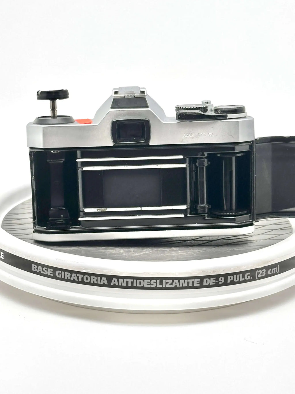 Silver and black vintage film camera with a metallic body, exposed shutter mechanism, and visible lens mount.