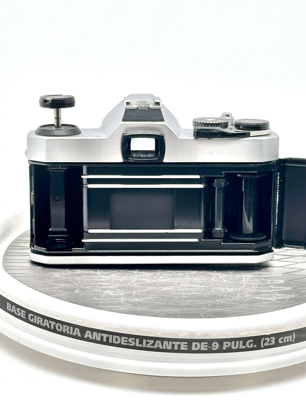 Silver and black vintage film camera with a classic rangefinder design, featuring exposed internal components and a textured grip.