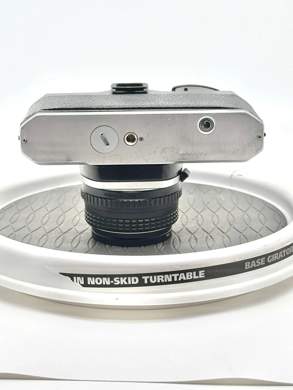 Silver-bodied, textured top camera with a black lens mounted on it.