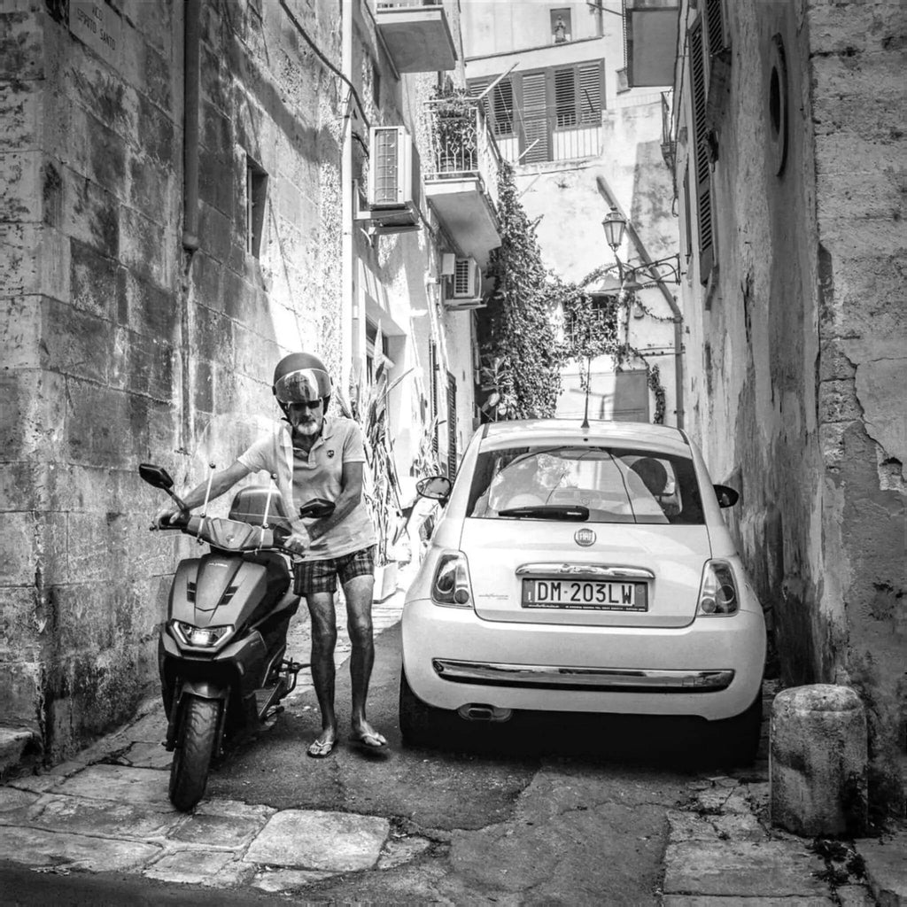 White fiat 500 parked in a narrow alleyway