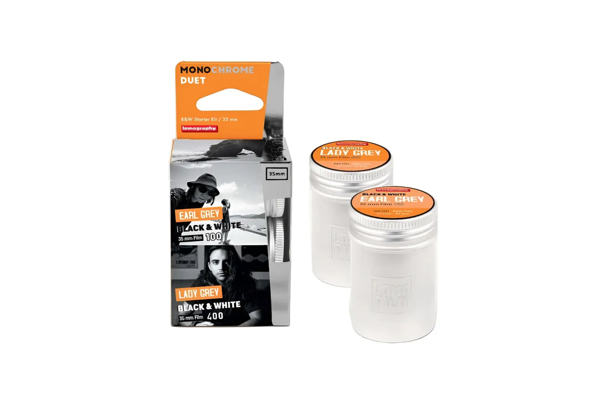 Two transparent cylindrical containers with orange lids, each labeled ’lady grey’ and marked as 35mm black & white film.