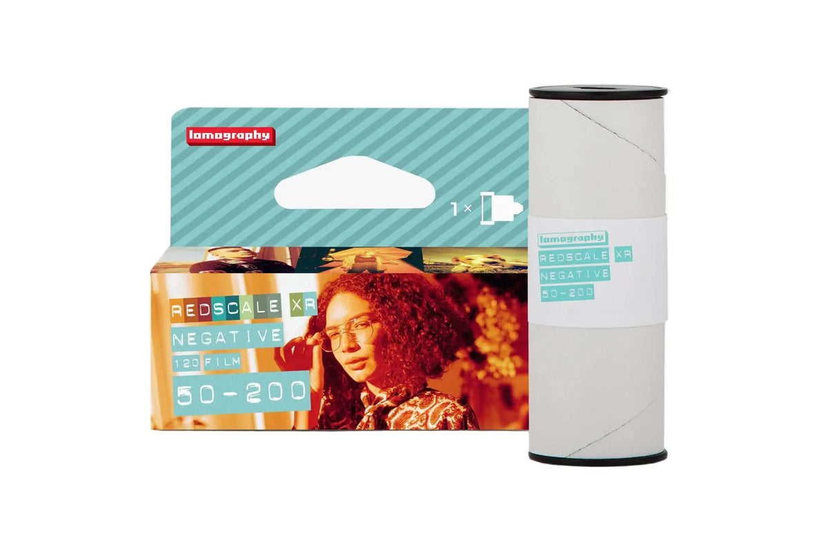 Lomography redscale xr 120 film roll in a teal and white package with a woman’s portrait on the front.