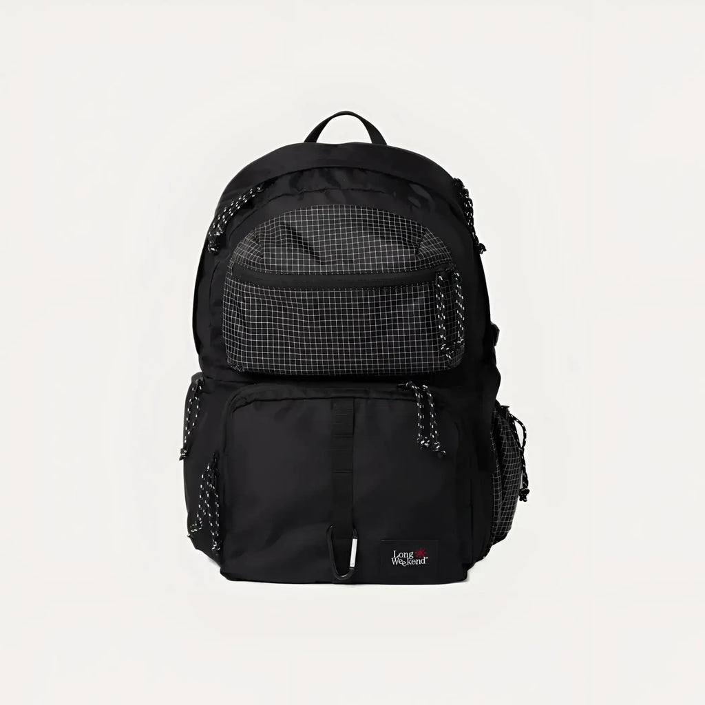Black backpack with a grid-patterned front pocket and textured side panels, featuring the ’long weekend’ brand logo on its lower right corner.