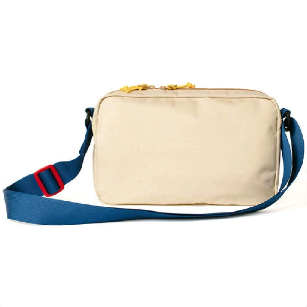 Beige nylon crossbody bag with a blue strap and red buckle, featuring yellow zipper pulls.