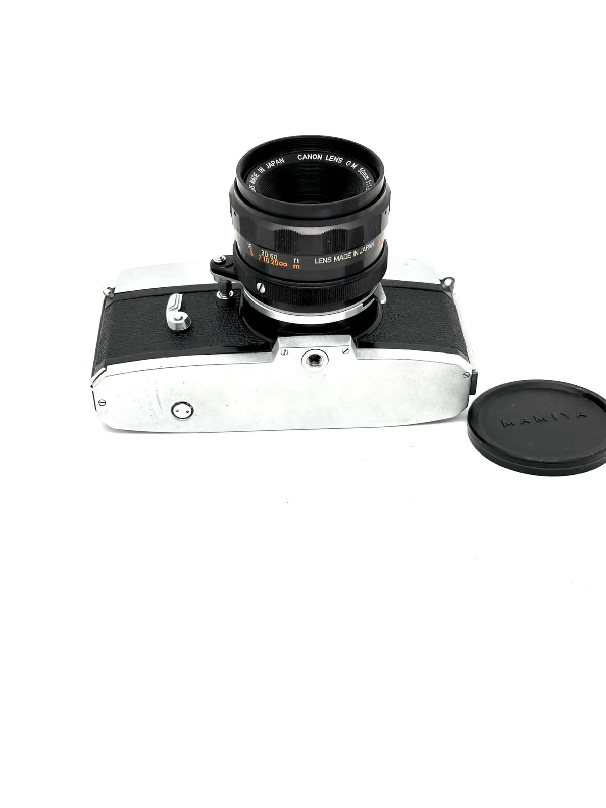 Silver and black canon camera body with a matching lens mounted on top.