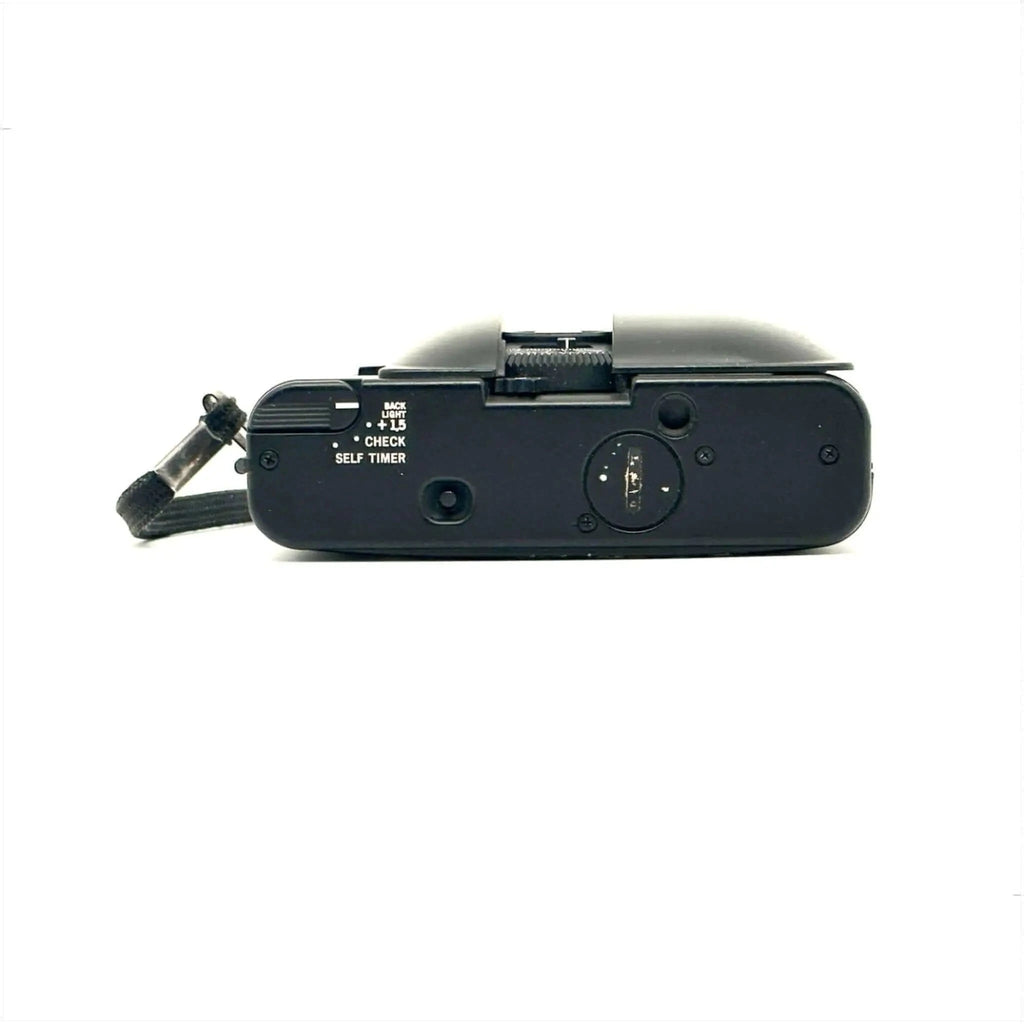 Black fujifilm compact camera with a textured grip and visible control dials.