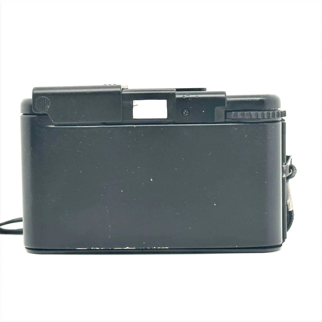 Black plastic compact camera with a textured grip and visible lens shutter mechanism.
