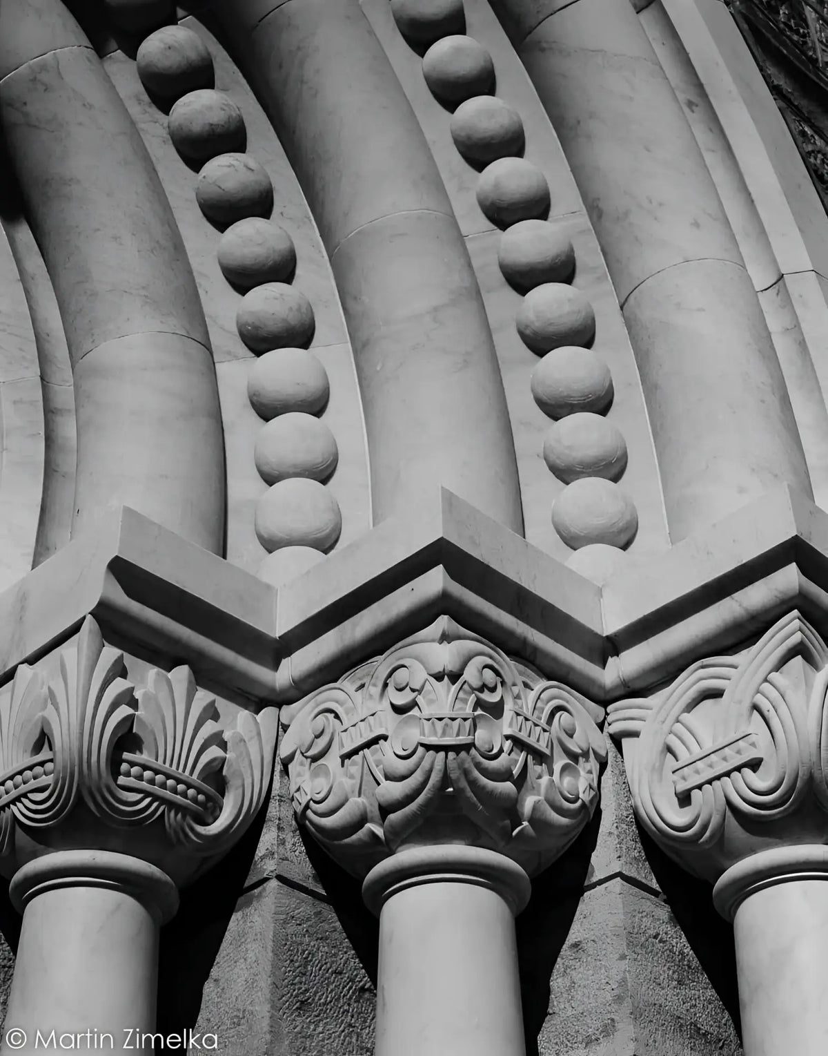 Carved stone columns with ornate capitals and spherical decorative elements.