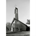 Modern brick church with a tall, angular bell tower topped by a cross.
